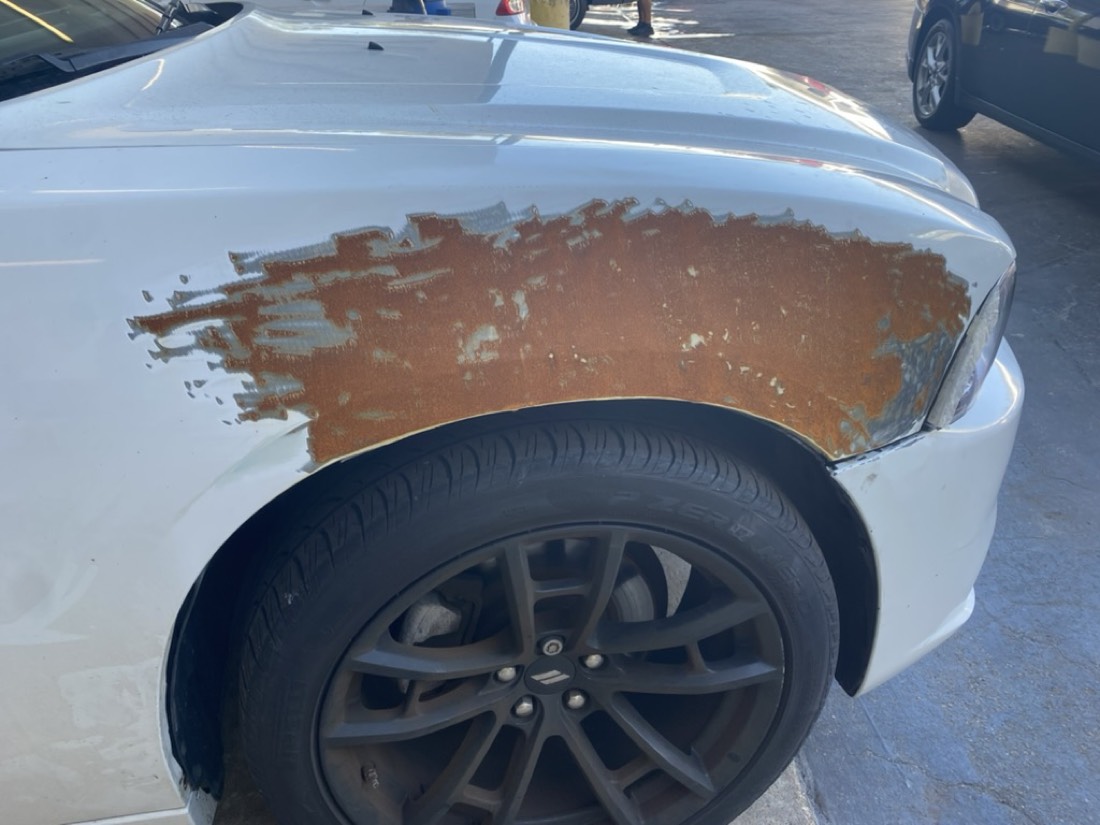 Rust corrosion bleeding through the paint on a vehicle fender