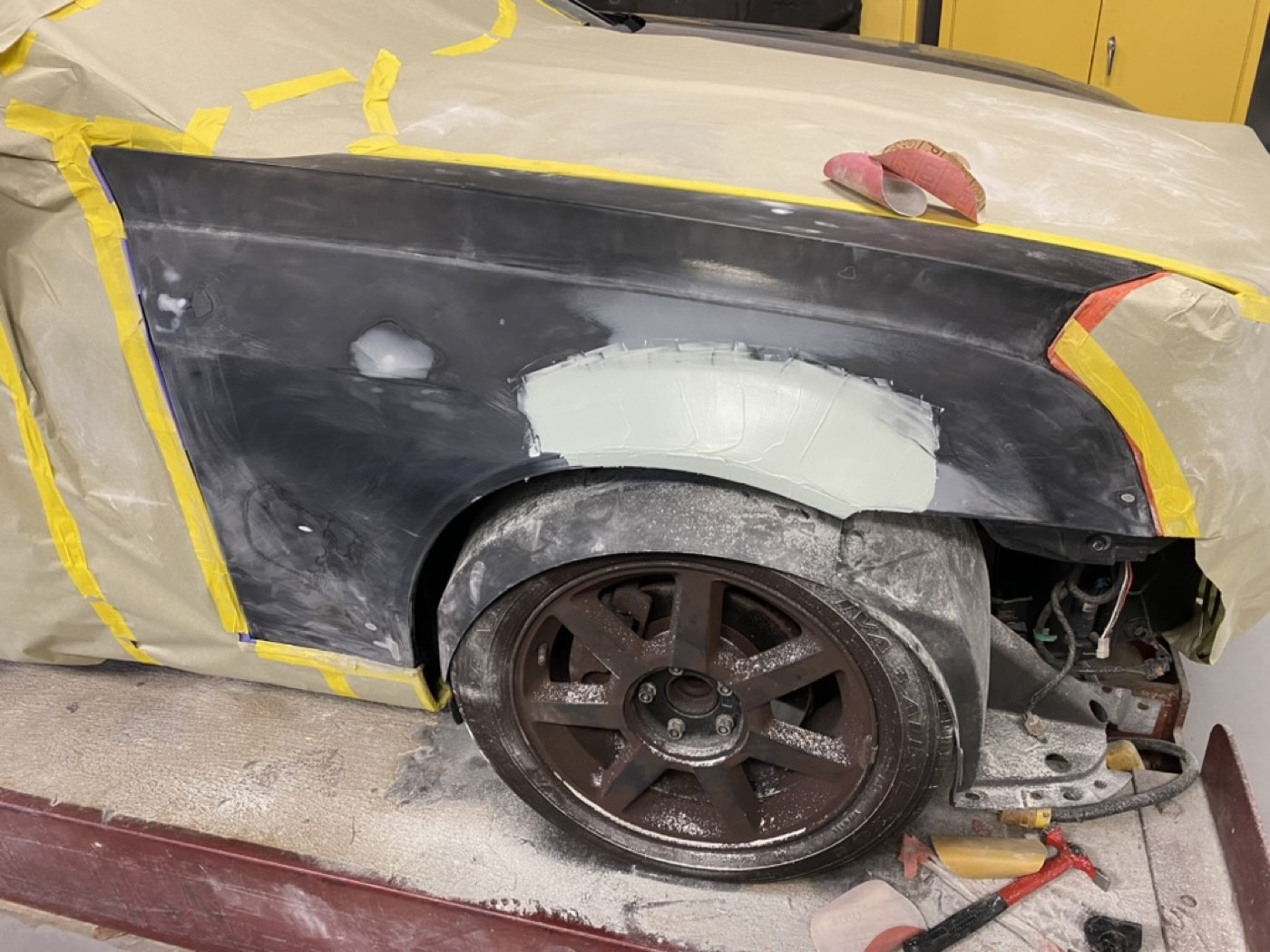 Surface rust and primer spots on a classic car body panel
