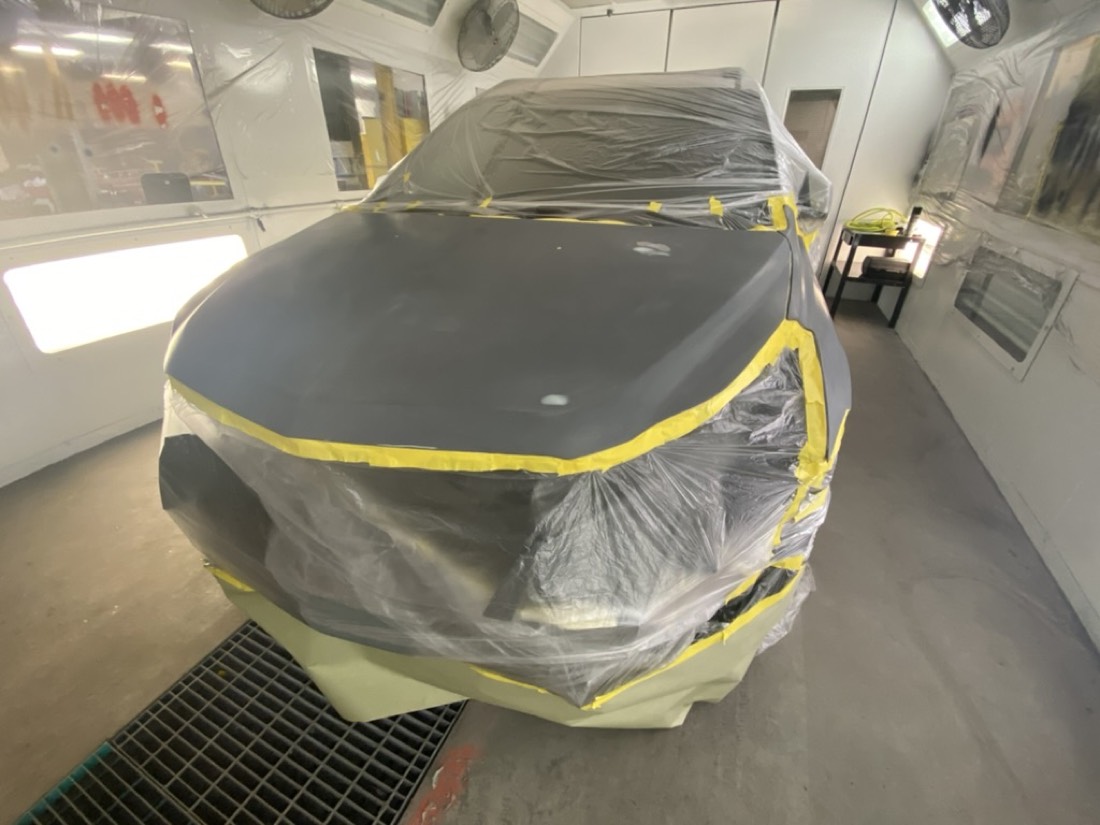 Vehicle masked and prepped in a spray booth for ASE B3 refinish work