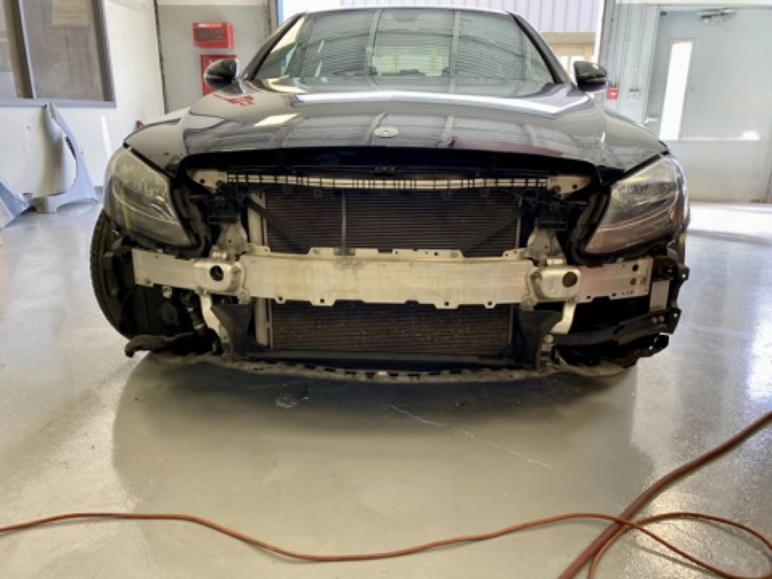 Collision-damaged vehicle with the front bumper removed during damage analysis